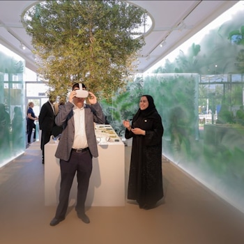 The RTA COP28 stand by Studio Königshausen in Dubai boasts an avant-garde design, featuring illuminated walls adorned with lush greenery, shaping an interactive, futuristic city model.